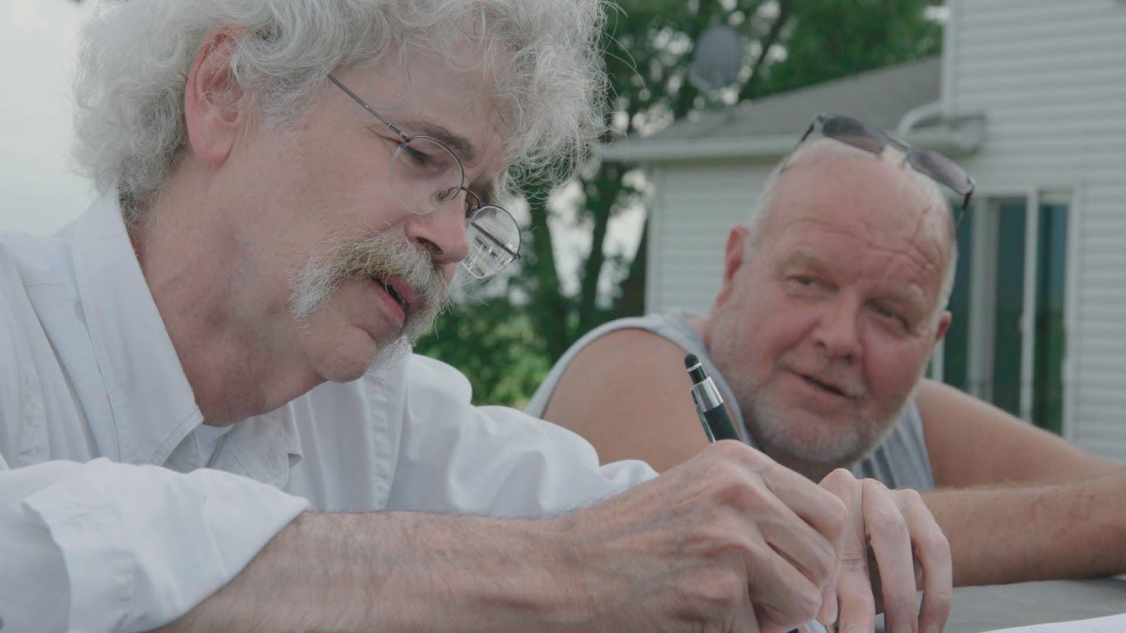 Art Cullen conducting an interview with another man outside