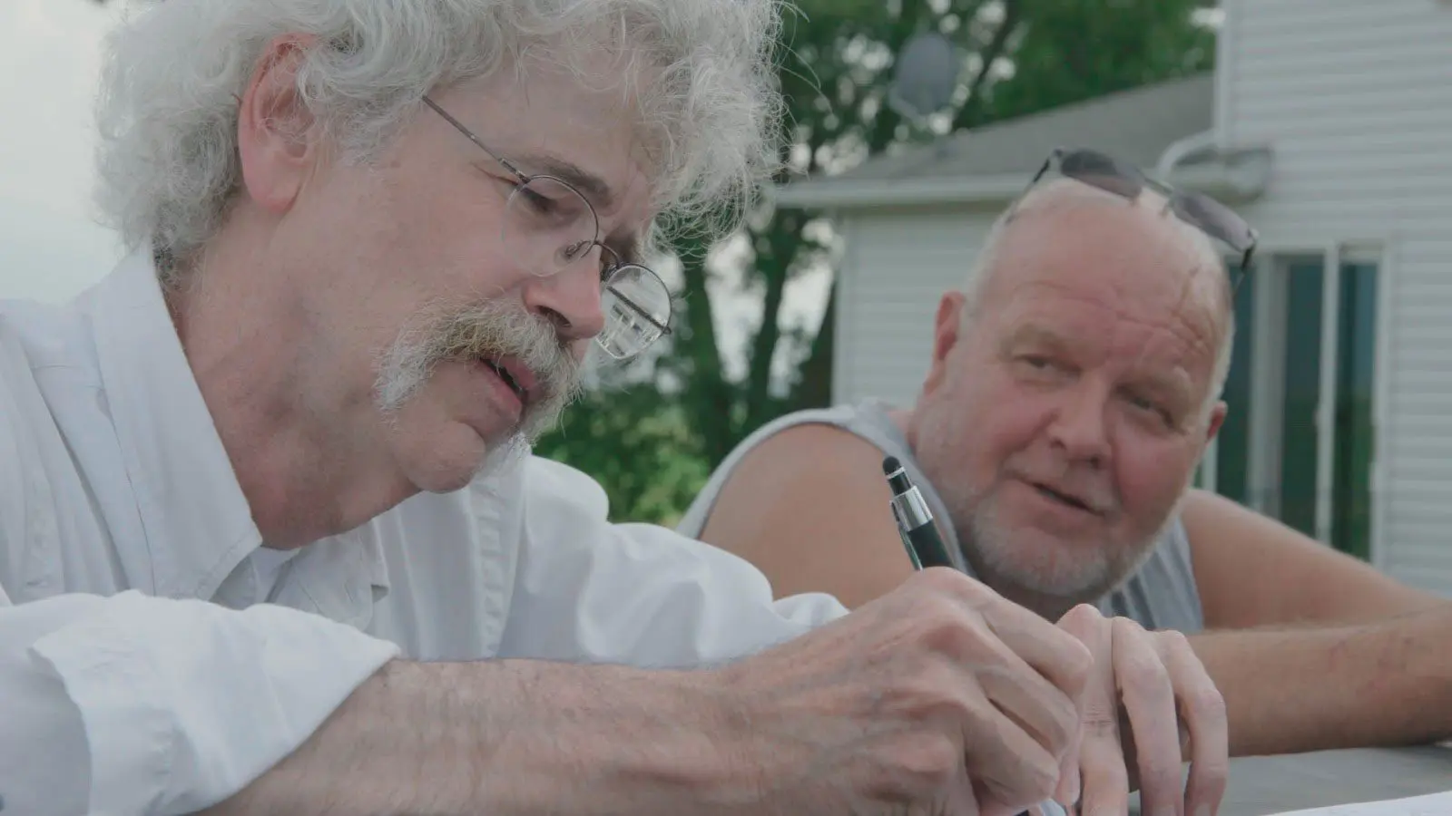 Art Cullen Interviews conducting an interview with another man outside